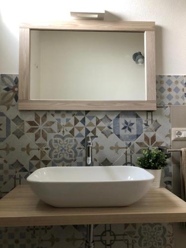 a bathroom with a white sink and a mirror at Domus Deiana Case Vacanza in San Giovanni Suergiu