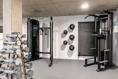 a fitness room with several rows of equipment at The Roebbek x Hanse in Hamburg