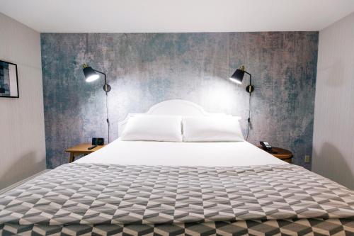 a bedroom with a large white bed with two lamps at Tarrytown House Estate in Tarrytown