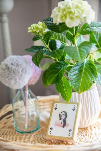 a table with two vases with flowers and a card at Mas Coeur Provence Calme Beauté Grand Parc in Pernes-les-Fontaines