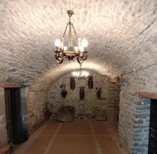 Ein Kronleuchter hängt von einem Steintunnel in einem Schloss in der Unterkunft Casa Biñuales in Pedruel