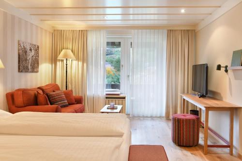 a hotel room with a bed and a couch at Ansitz Pünthof in Lagundo