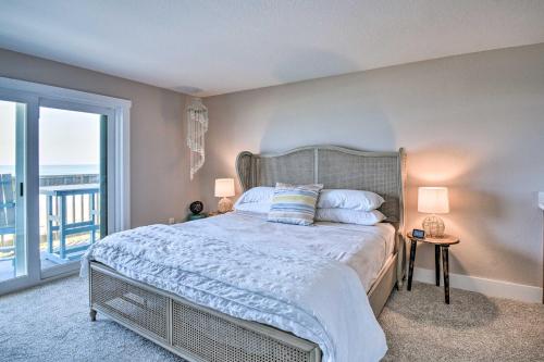a bedroom with a large bed and a balcony at Beachfront Nags Head Condo with Private Balcony! in Nags Head