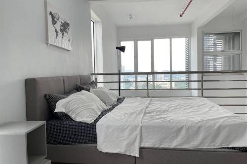 a bedroom with a bed with white sheets and pillows at Putrajaya Bangi Minimalist Loft 1 Wifi Netflix in Kajang