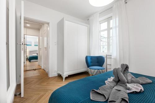 sypialnia z niebieskim łóżkiem i niebieskim krzesłem w obiekcie Holiday Sopot Apartment w mieście Sopot