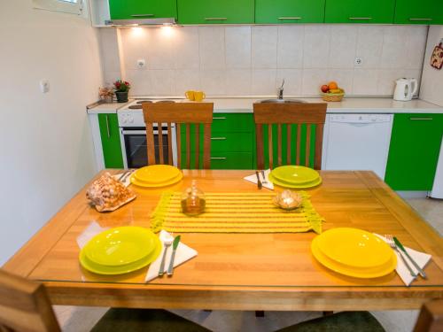 a kitchen with a wooden table with yellow plates at Green Home Apartments in Kotor
