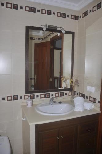 a bathroom with a sink and a large mirror at La Luz de Vejer in Vejer de la Frontera