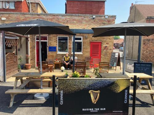 a man sitting at a table under two umbrellas at The Star Inn in Nafferton