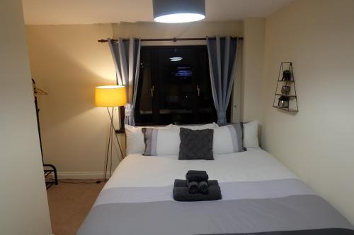 a bedroom with a large white bed with a lamp at 15 Bronant in Talgarth