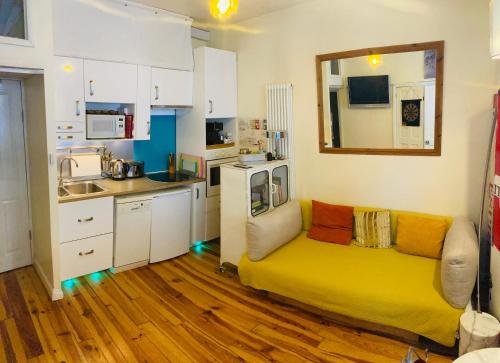 a living room with a yellow couch in a kitchen at Two Top Central Unique Artisan Beach Studios - also separate spa cabin in Brighton & Hove