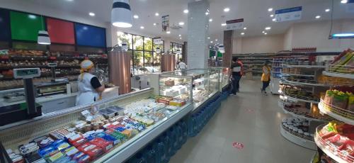 a grocery store with people standing in the produce section at Happy Stay Hotel in Kutaisi