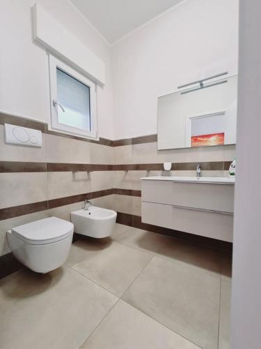 a bathroom with a toilet and a sink at Villa Zizzari A Due Passi Dal Mare in Torre Lapillo