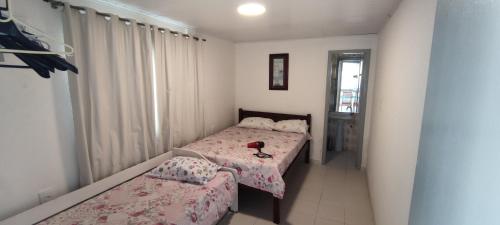 um pequeno quarto com 2 camas e uma janela em DK3 - CaSA COM 3 SUITES COM PISCINA BRUNO KLEMTZ em Itapema