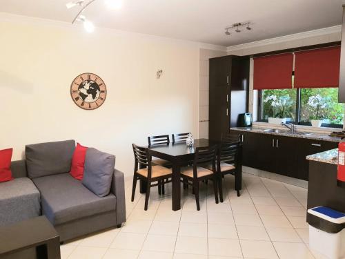 a living room with a couch and a table and chairs at Jardins de Pera vila M in Pêra
