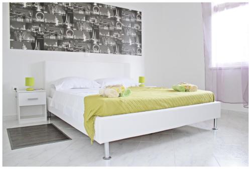1 dormitorio blanco con 1 cama con manta amarilla en Apartments & Room Dijana, en Trogir