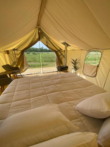 a large bed in a tent with a view at Off Map Glamping in South Haven