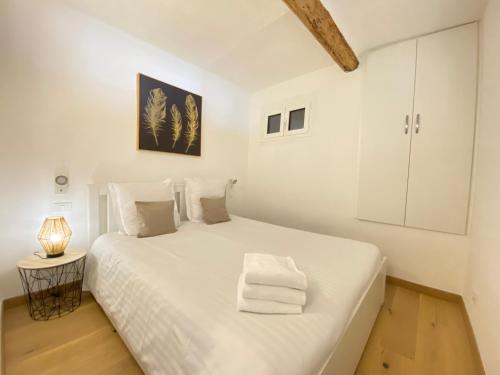 um quarto branco com uma grande cama branca e um candeeiro em Vieux Château em Menton