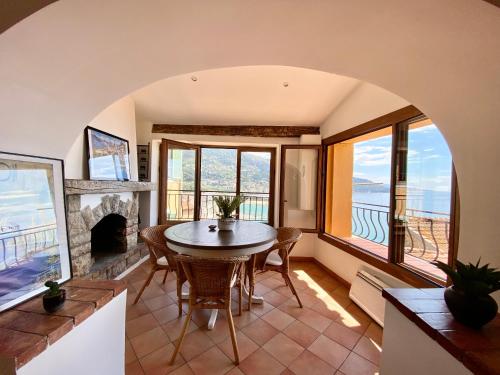 une salle à manger avec une table et une cheminée dans l'établissement Vieux Château, vue mer, à Menton