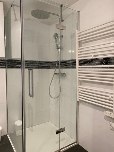 une douche avec une porte vitrée dans une salle de bain dans l'établissement Vieux Château, vue mer, à Menton