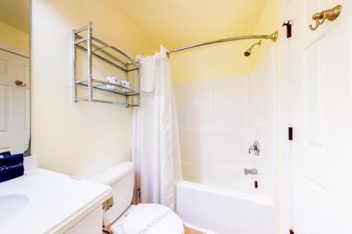 a bathroom with a white toilet and a shower at Driftwood Villa - 287 in Edisto Beach