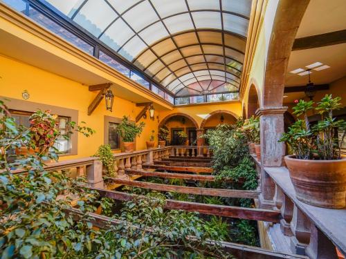 a building with a glass ceiling and stairs with plants at Hotel Mansión Virreyes by Rotamundos in San Miguel de Allende