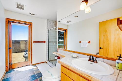 ein Bad mit einem Waschbecken, einem WC und einem Fenster in der Unterkunft Stoney House in Sea Ranch