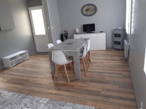 een eetkamer met een tafel en witte stoelen bij Villa 27 in Le Tréport