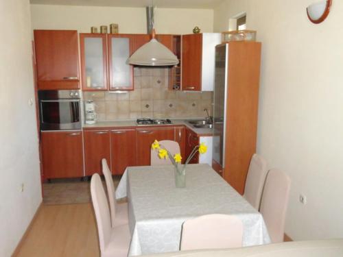 una cucina con tavolo e vaso di fiori di Apartment in Palit with Terrace, Air conditioning, Wi-Fi (4603-1) a Mundanije