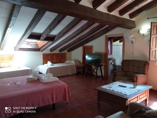 a hotel room with two beds and a tv at El Humilladero in Mogarraz