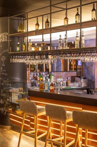 a bar with two chairs and a counter with glasses at Ibis Styles Lisboa Centro Liberdade NE in Lisbon