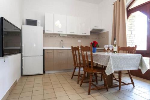 Il comprend une cuisine équipée d'une table, de chaises et d'un réfrigérateur. dans l'établissement Apartment Pakostane (3475-2), à Pakoštane