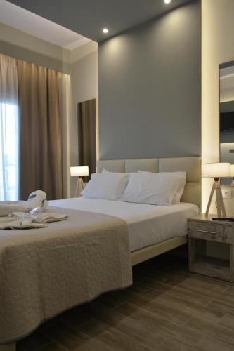 a bedroom with a large white bed and a window at Villa Georgio Paralia in Paralia Katerinis