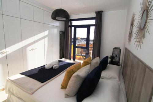 een slaapkamer met een bed met kussens en een raam bij Bahia Meloneras in Meloneras