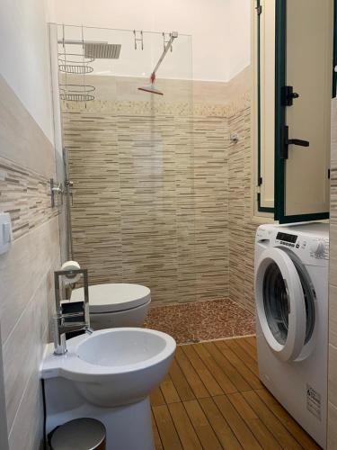 a bathroom with a toilet and a washing machine at La Terrazza su Trapani - Alloggio Roma in Trapani