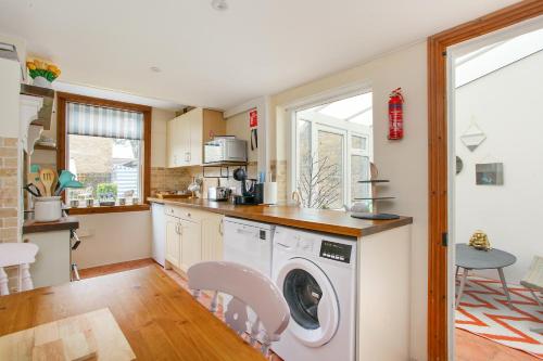 a kitchen with a washer and dryer in it at Sea Salt Cottage - Mins to beach & shops Dog Friendly in Deal