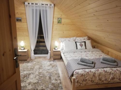 um quarto com uma cama numa casa de madeira em GRABSKA OSADA APARTAMENTY - 100m od Suntago Park-domki ogrzewane całoroczne em Mszczonów