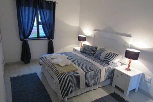 a bedroom with a bed and two lamps and a window at Leander's Cottage - your dream stay in mind in Swakopmund