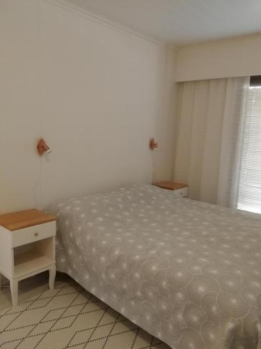 1 dormitorio con cama, mesa y ventana en Huoneisto Villa Kaitera en Kuusamo