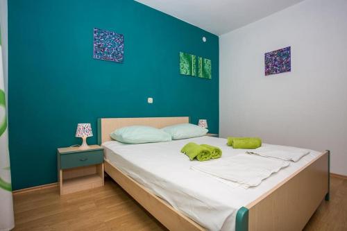 sypialnia z dużym łóżkiem i niebieską ścianą w obiekcie Apartment in Njivice with Seaview, Balcony, Air condition, WIFI (4687-2) w mieście Nijvice
