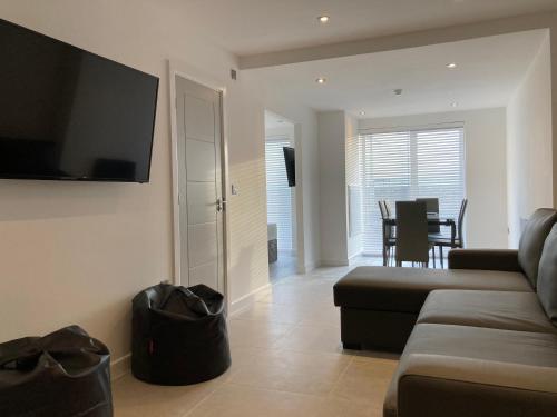 a living room with a couch and a flat screen tv at Coastal Plaza in Blackpool