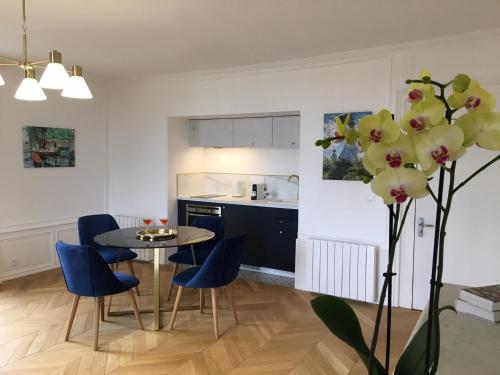 a kitchen and living room with a table and chairs at La Promenade - Appartement de charme avec vue sur le canal et ses écluses - Centre historique in Redon