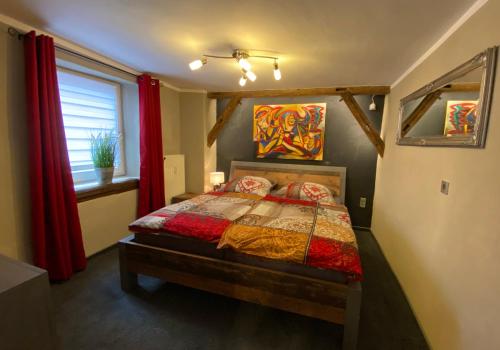 a bedroom with a bed and a window with red curtains at Appartement Schlossberg, Gasthaus Hirsch in Hirschhorn