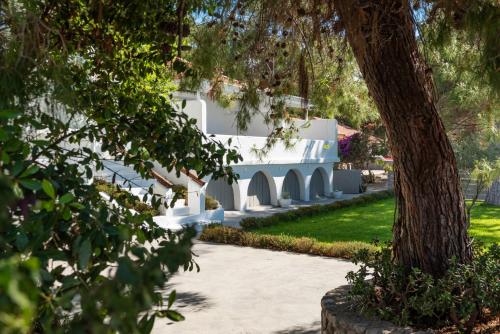 a building in a park with a tree at Casa Montzo boutique hotel in Katelios