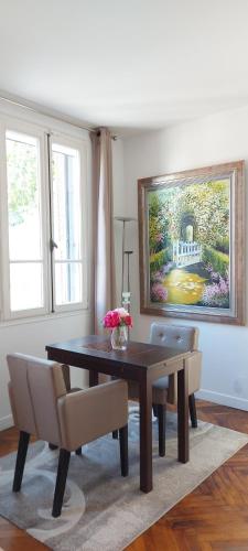 une table de salle à manger avec des chaises et un tableau au mur dans l'établissement Villa Angelus, à Nice