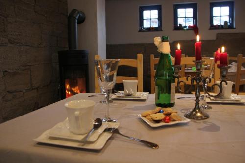 a table with a bottle of wine and a plate of food at Hainich-Zeit in Eigenrieden