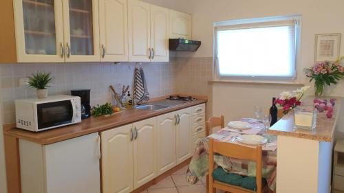 uma cozinha com uma mesa e um micro-ondas em Appartamento da Vjeri em Pula