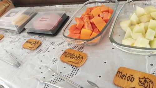 een tafel met twee bakken fruit en kaas bij Pousada Chateau Sophie in Itanhaém