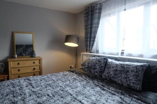 a bedroom with a bed and a window and a dresser at 15 Bronant in Talgarth