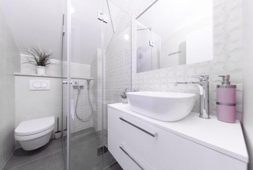 a white bathroom with a sink and a toilet at Villa Aida in Komiža