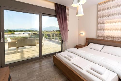 a bedroom with a large bed and a balcony at Villa Kyros in Korinos